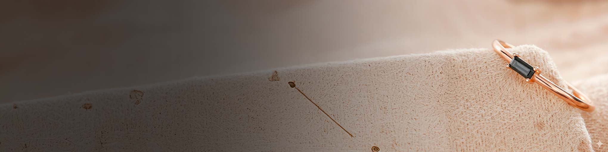 18K rose gold black diamond set ring, modern fine jewellery delicately positioned on luminous textured surface