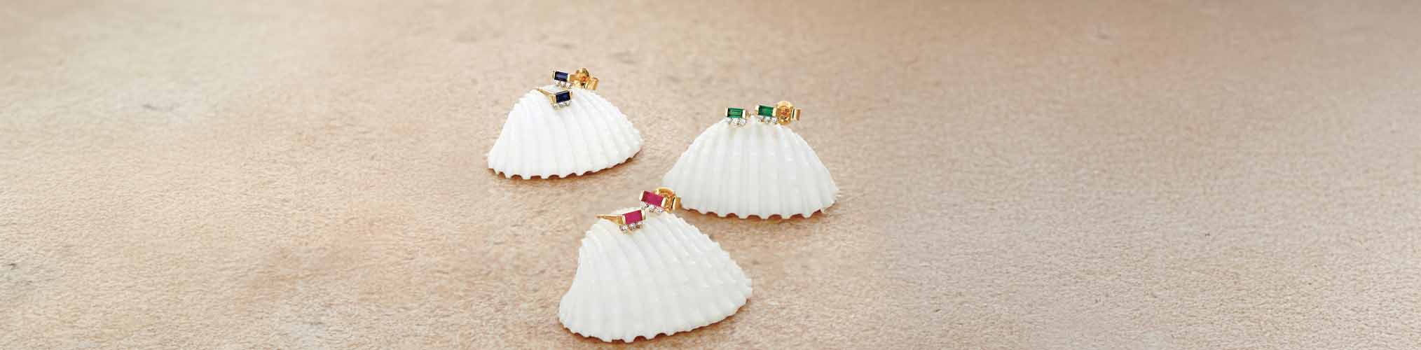18K yellow gold ear studs with blue sapphire, emerald and ruby gemstones on white shells