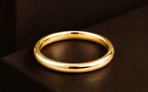 Bague en or jaune 18 carats massif posée sur cuir brun, lumière chaude valorisant l'éclat du métal