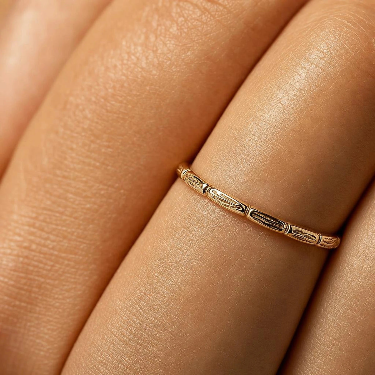 Sobek ring worn on the finger, macro on the chiselled crocodile scales in yellow gold