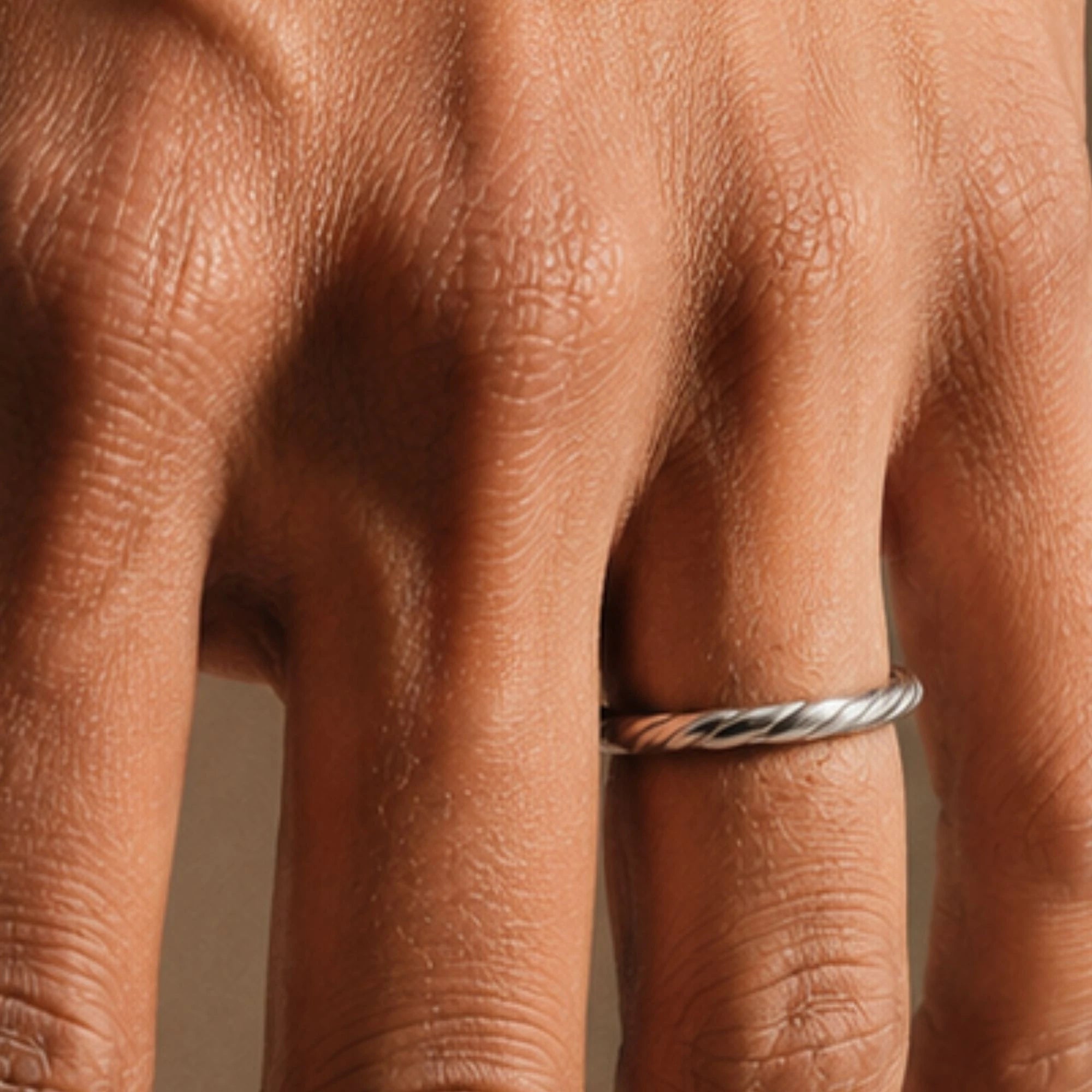 Vasuki twisted white gold band worn on a man's finger