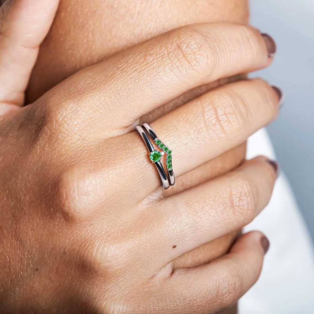 A yellow gold and Emerald ring worn on the ring finger, a symbol of commitment and elegance