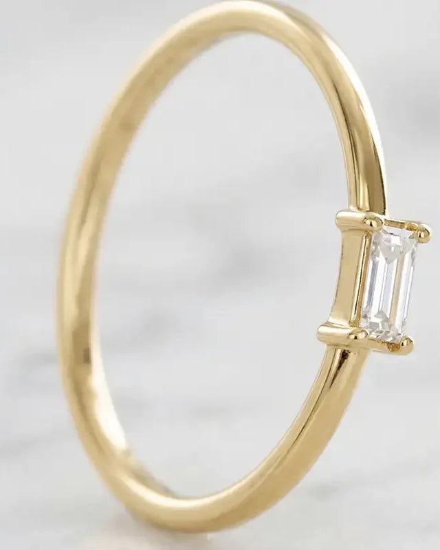 Bague de fiançailles solitaire diamant baguette en or jaune 18 carats par Mayuri, sur fond élégant