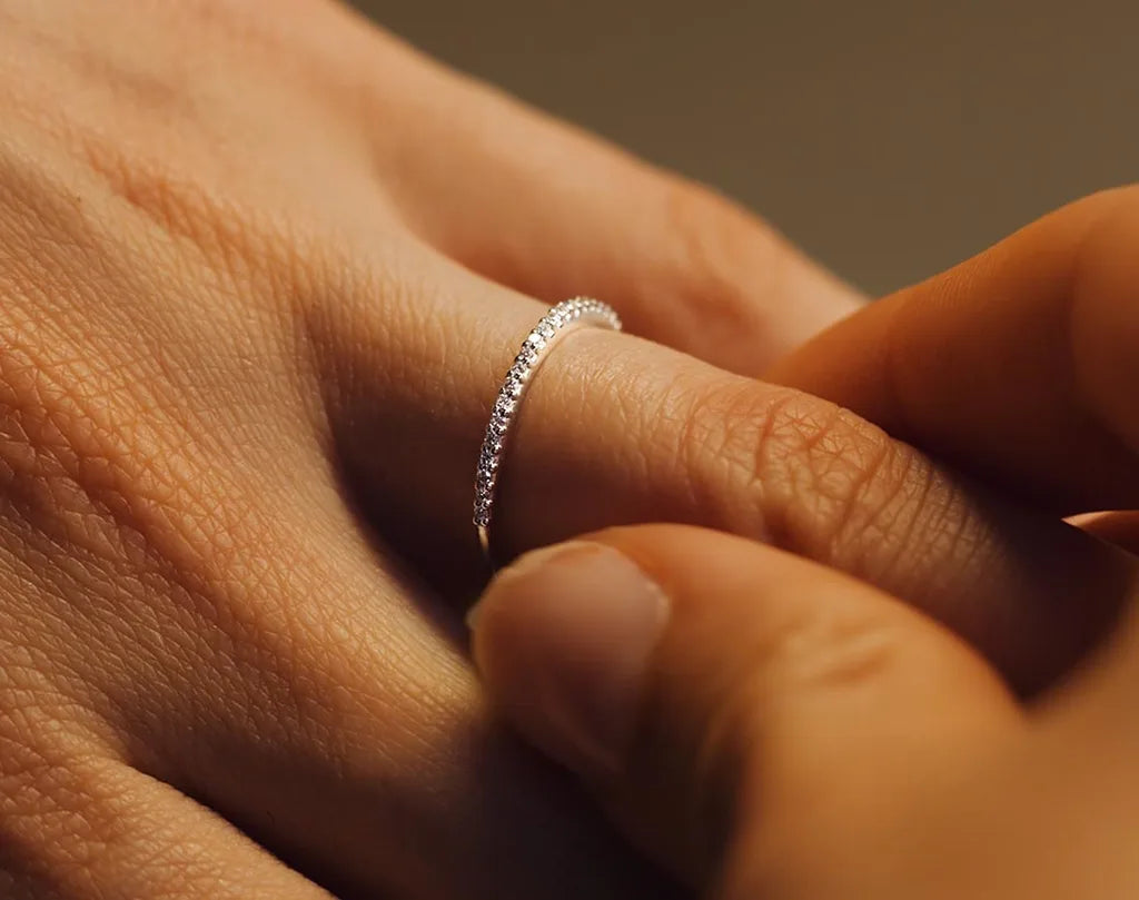 A fine Diamond pave wedding ring in 18K White Gold worn on the finger, a symbol of commitment by Mayuri
