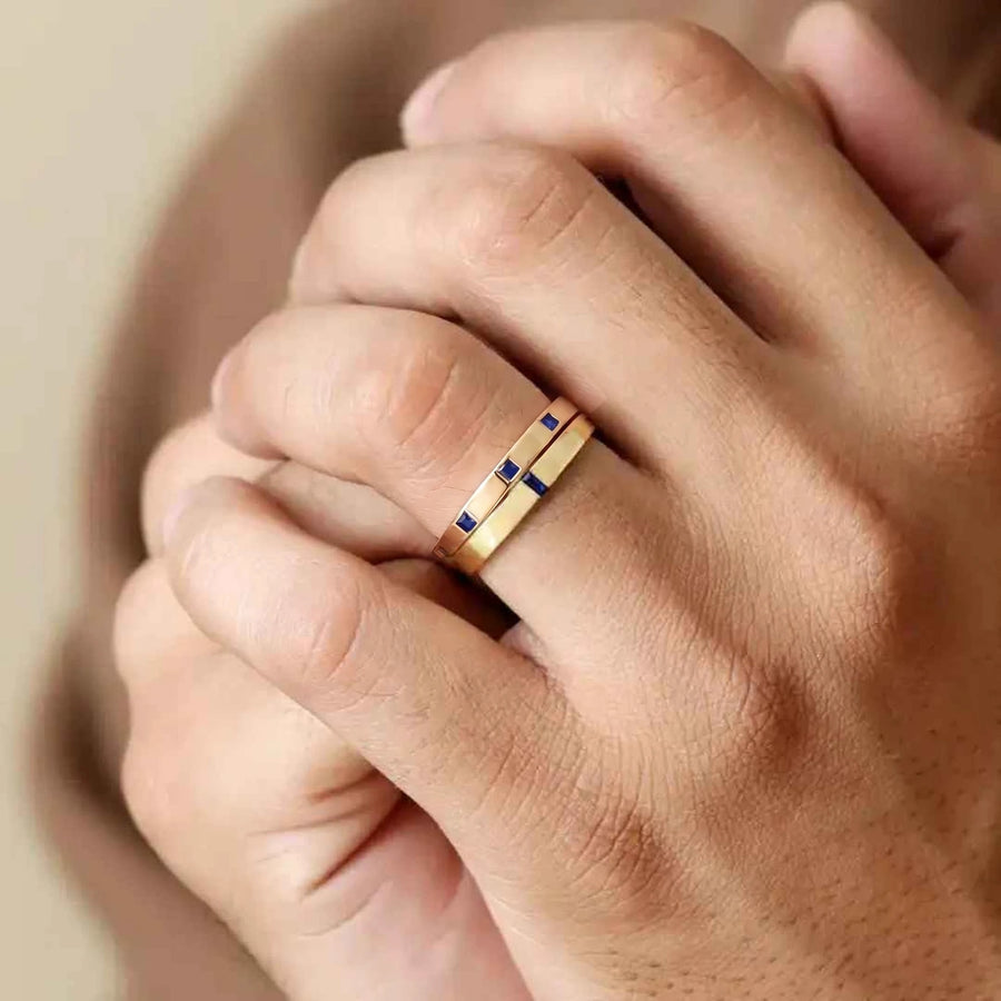 Bagues Viyom et Agni en saphir et or jaune 18 carats superposées sur une main d'homme