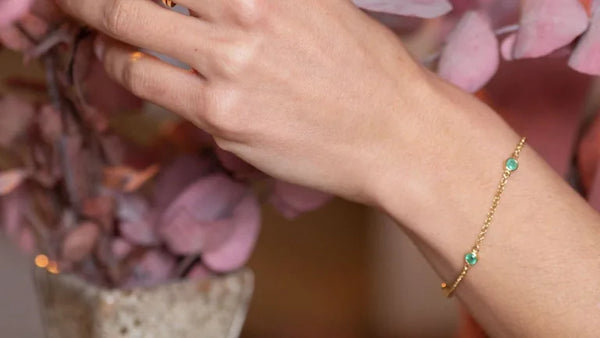 Dhanya bracelet in emerald and yellow gold worn on the wrist, a maid of honor gift idea