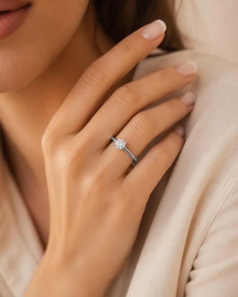 Bague de fiançailles solitaire diamant en or blanc portée sur main féminine élégante