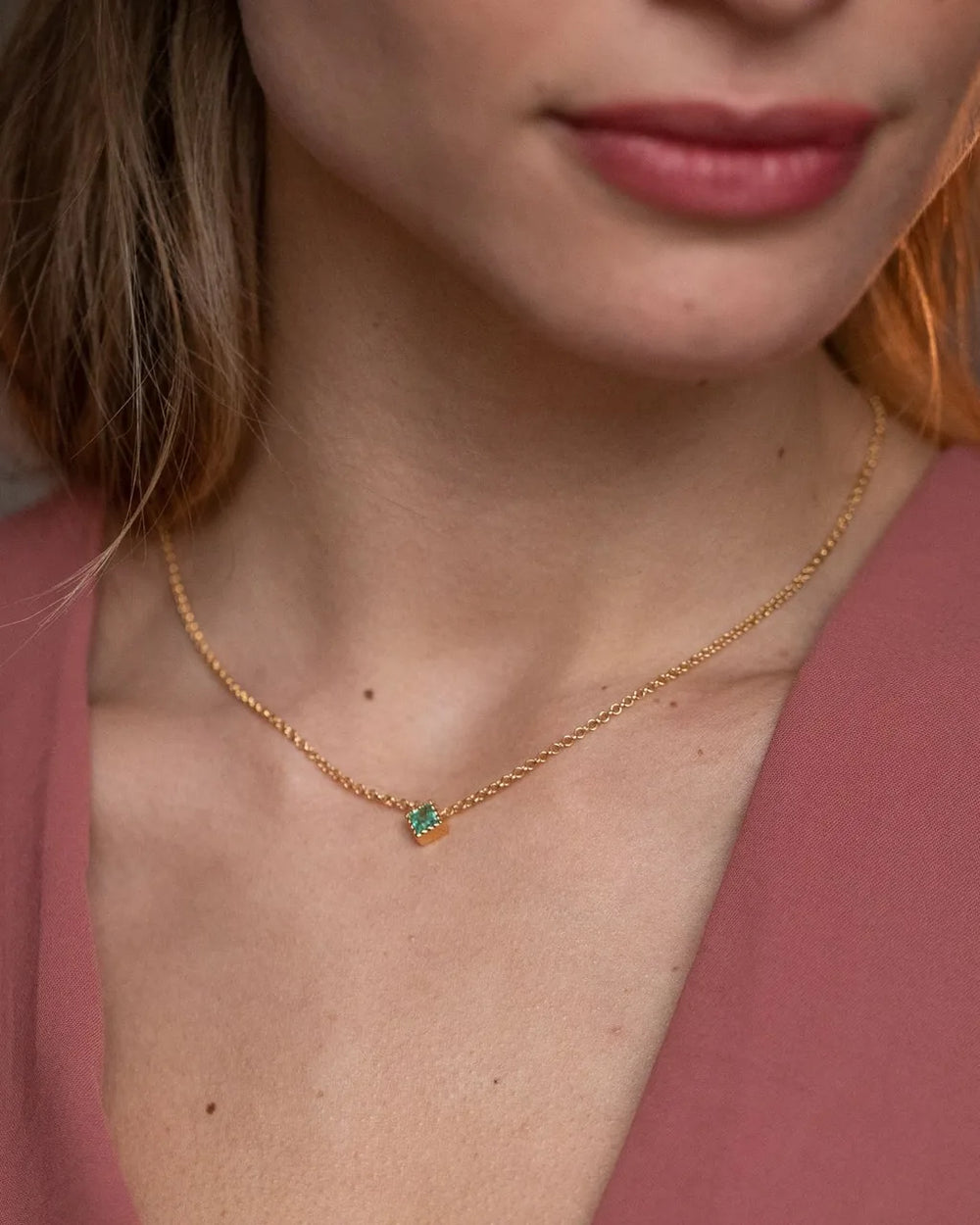 Indrani necklace in 18K yellow gold with emerald and fine chain worn at neck by Mayuri