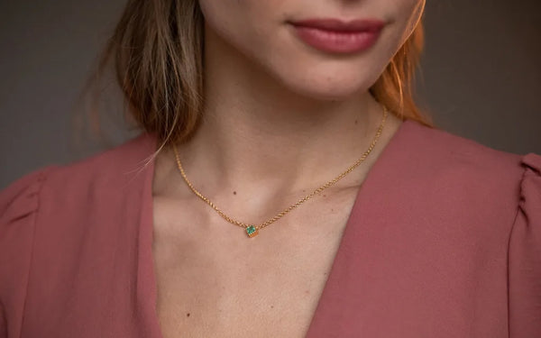 Indrani necklace in 18K yellow gold with emerald and fine chain worn at neck by Mayuri