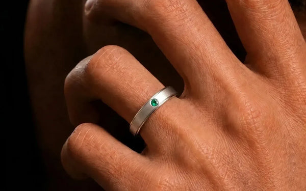 18K white gold bangle set with emerald worn on finger by Mayuri