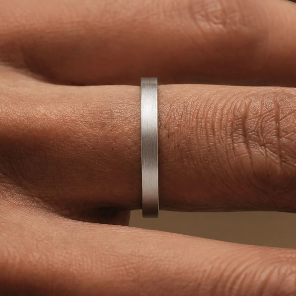 A platinum wedding ring with a matte brushed finish worn on the finger, everyday care by Mayuri