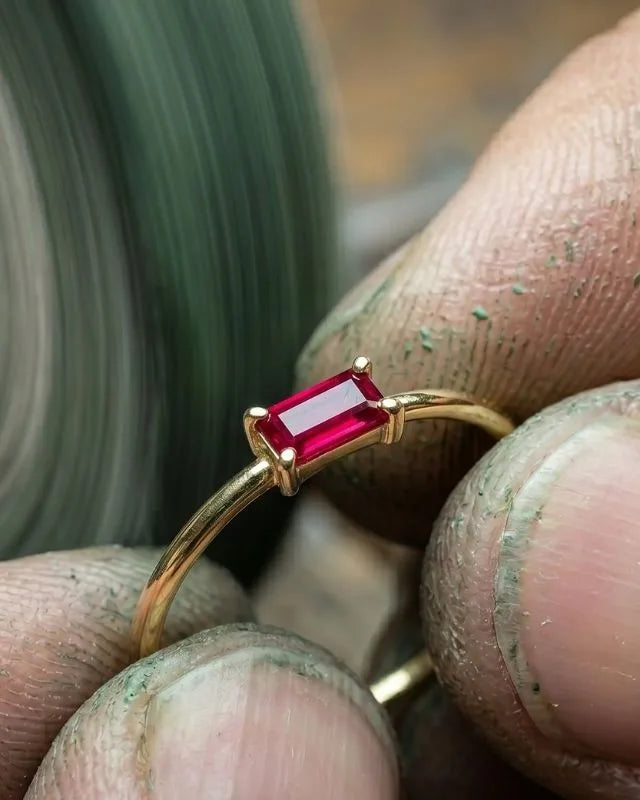 Jewellery set with a red stone, held before a polishing disc in the Mayuri workshop