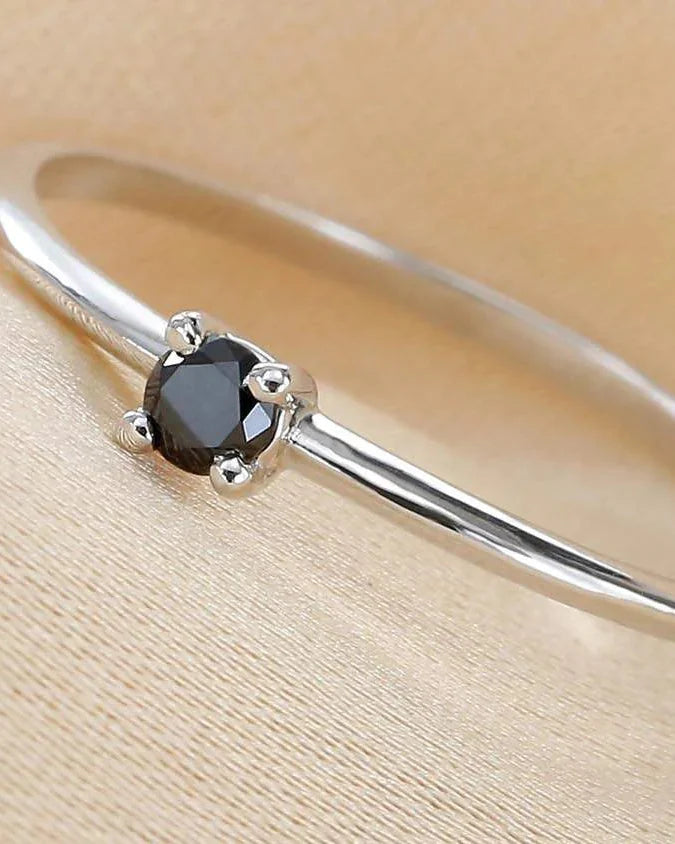 Saral ring set with a black diamond, worn on the finger