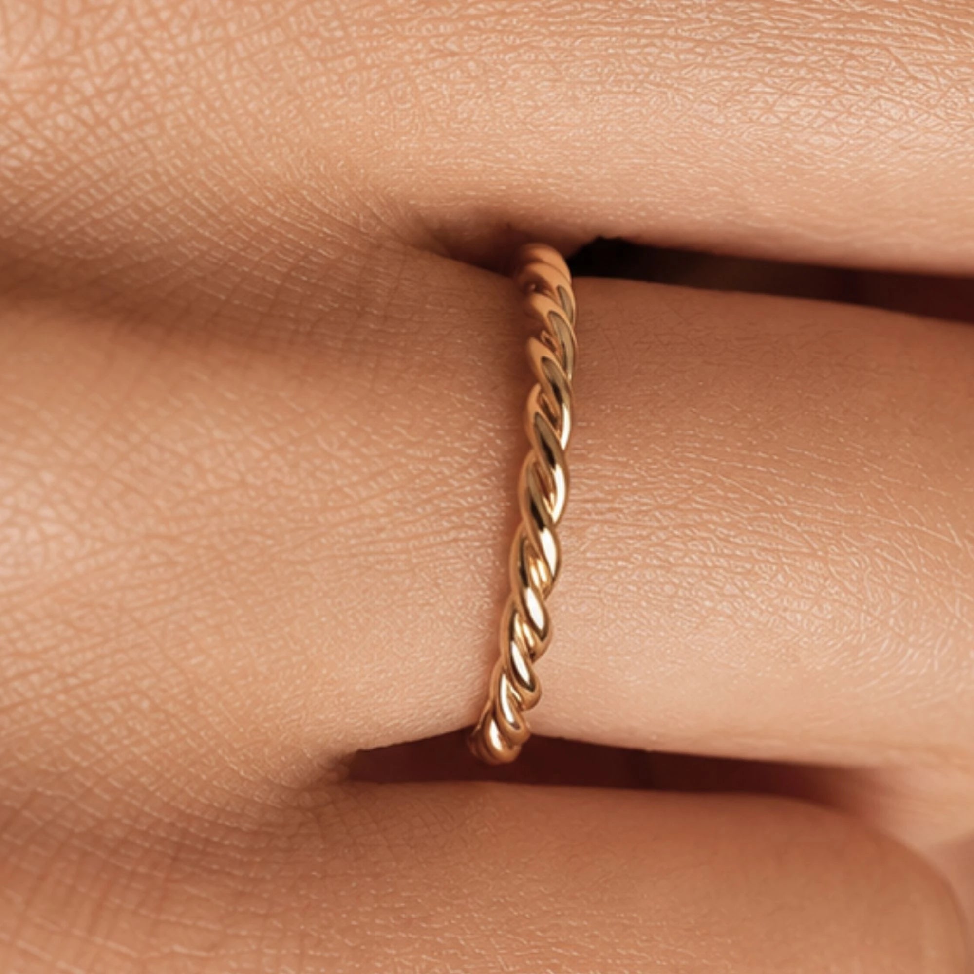 Musubi twisted gold band worn on the finger, fine rope-effect ring