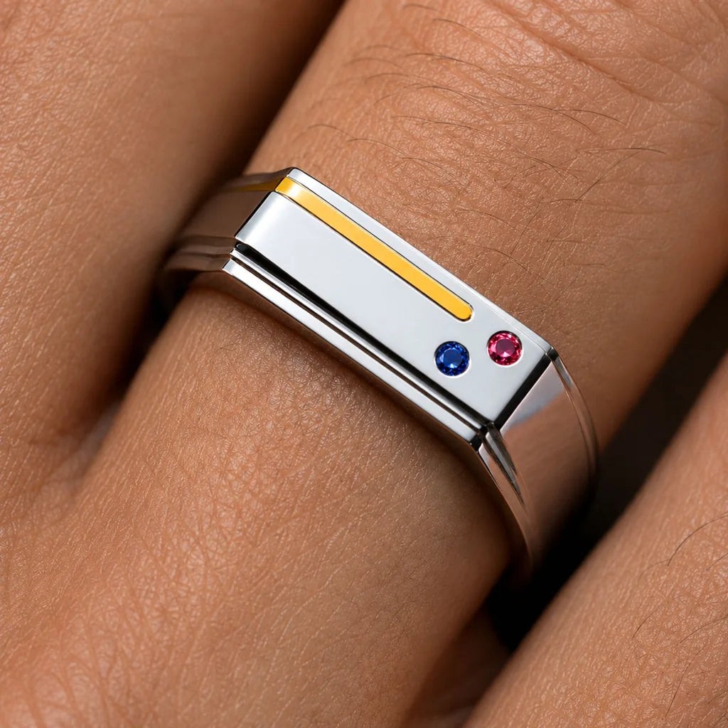 The Essence de Bandor ring in platinum and 18K yellow gold, with an inlaid gold thread and flush-set Ruby and Sapphire: a two-metal piece receives a hallmark for each metal