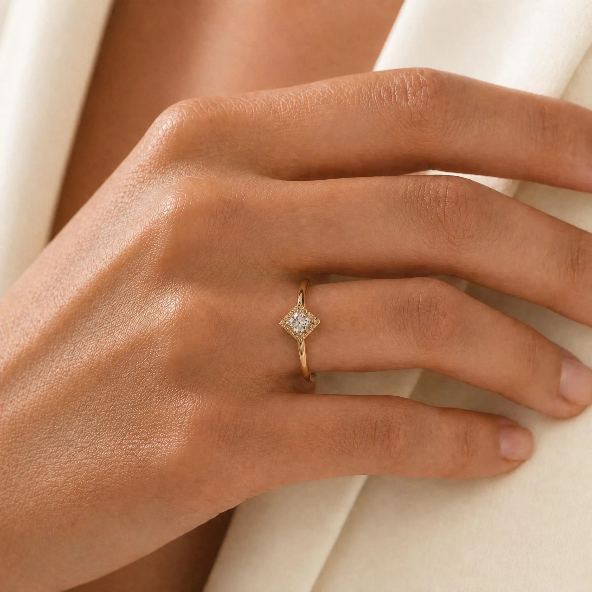 Indrani diamond engagement ring worn on the hand, princess-cut solitaire in twisted rope setting, 18K yellow gold