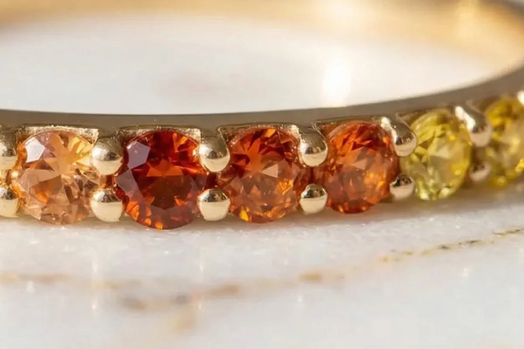 Kiran Sunset Sapphire ring, close-up on the 9 sapphires in an orange-to-yellow gradient